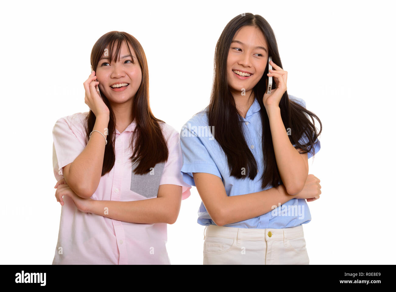 Zwei junge gerne asiatische Mädchen lächelnd und Sprechen auf Mobil Stockfoto