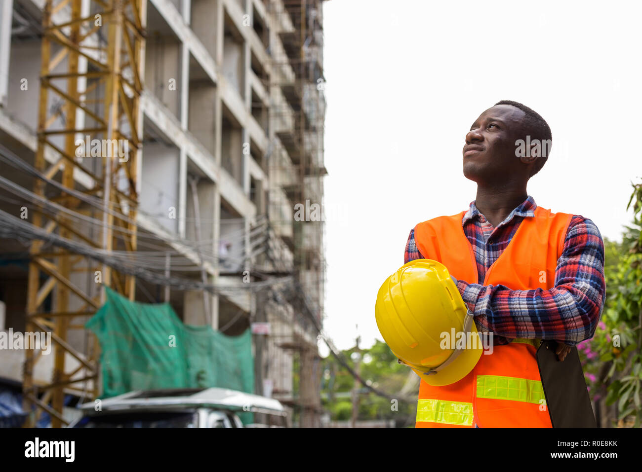 Nachdenklichen jungen schwarzen afrikanischen Mann Bauarbeiter Holding c Stockfoto