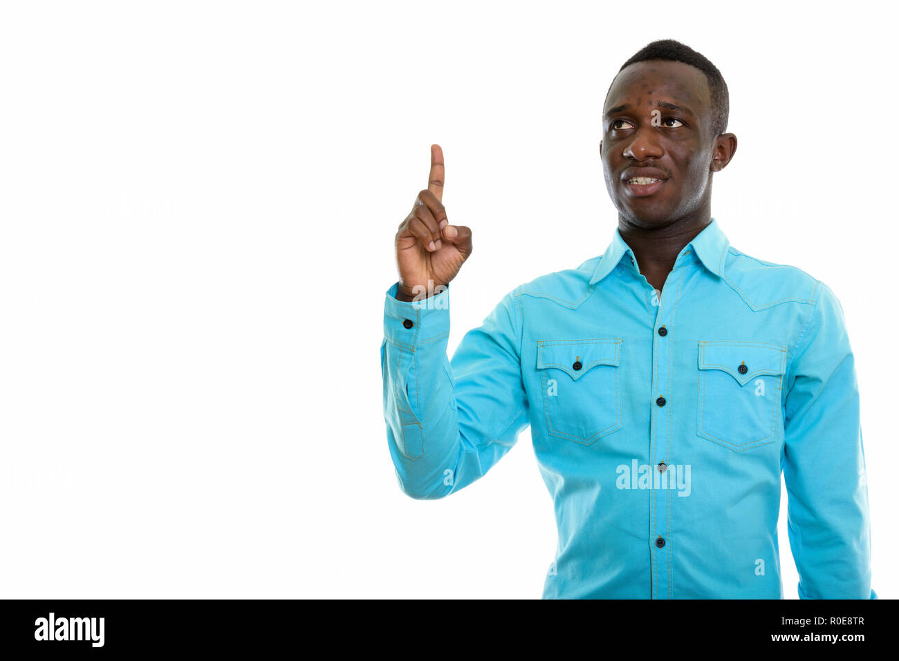 Studio shot der jungen schwarzen afrikanischen Mann glücklich lächelnd und denkst Stockfoto