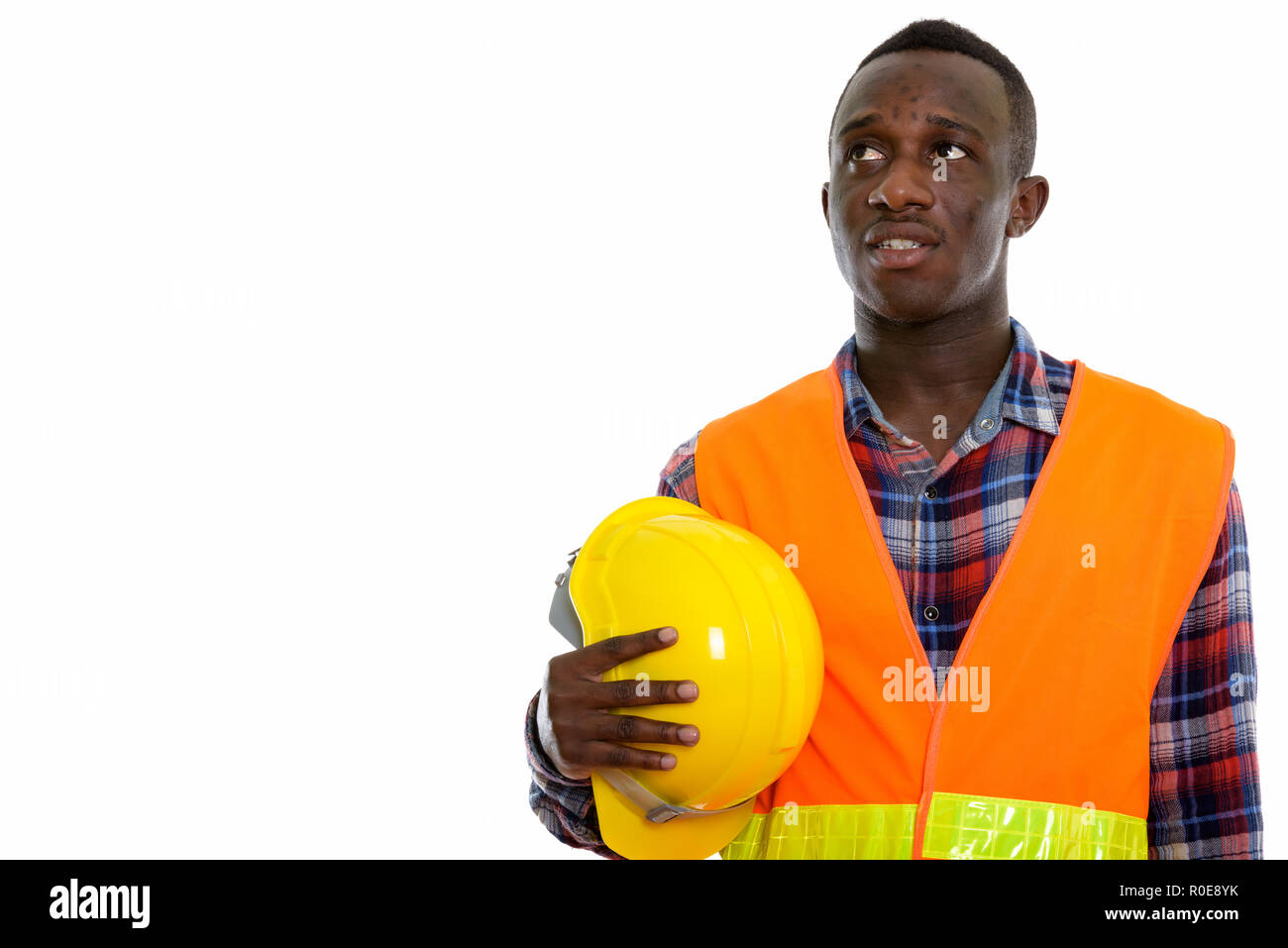 Studio shot von jungen schwarzen afrikanischen Mann Bauarbeiter denke Stockfoto