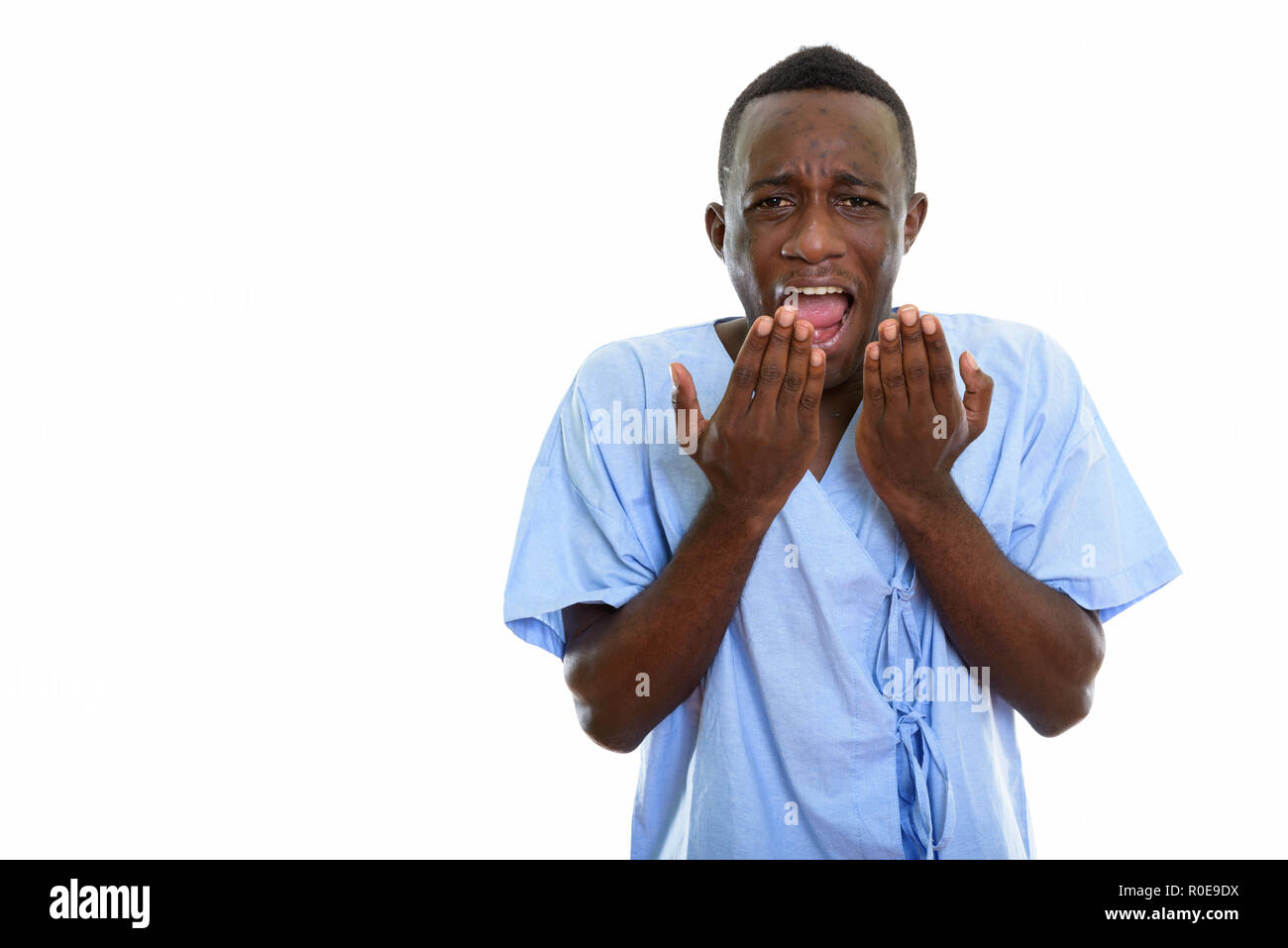 Studio shot der Jungen glücklich schwarzen afrikanischen Mann geduldig lächelnd und Stockfoto