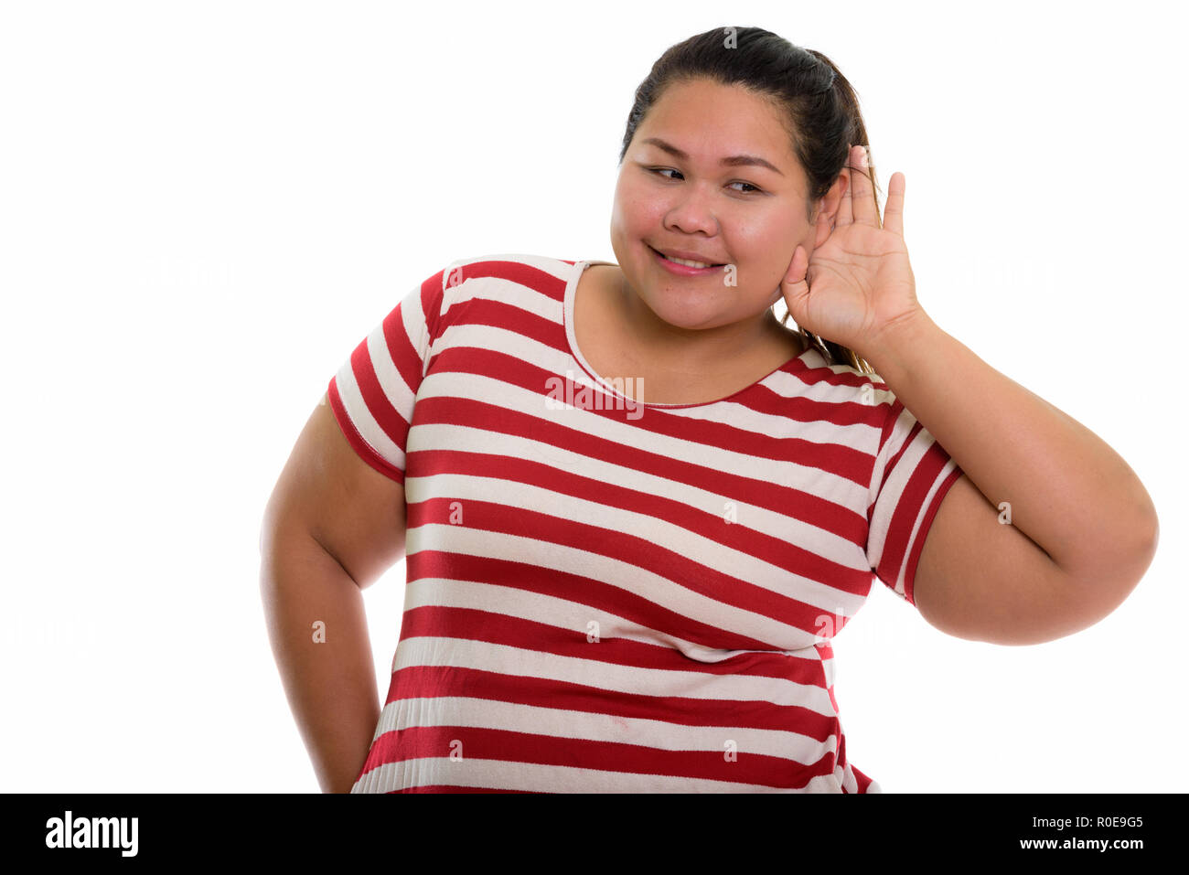 Studio shot der Jungen gerne Fett asiatische Frau lächelnd und Zuhören Stockfoto