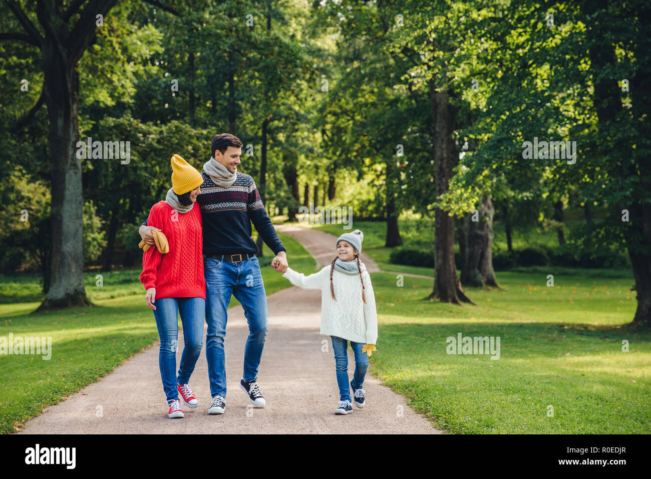 Glückliche Eltern Stolz auf ihre kleine schöne Tochter, gehen gemeinsam im Park haben, Herbst Wetter zu genießen. Familie Rest an Wochenenden über Stockfoto