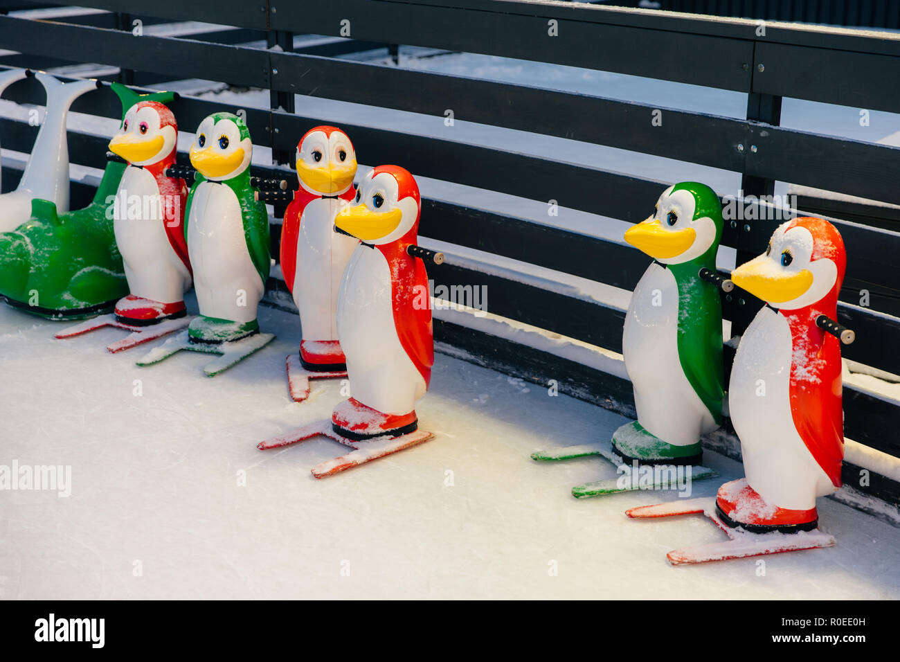 Schuß von bunten Figuren in Form von Pinguinen, zum Eislaufen auf der Eisbahn, Menschen helfen, um Gleichgewicht zu halten und nicht fallen und verletzt Stockfoto