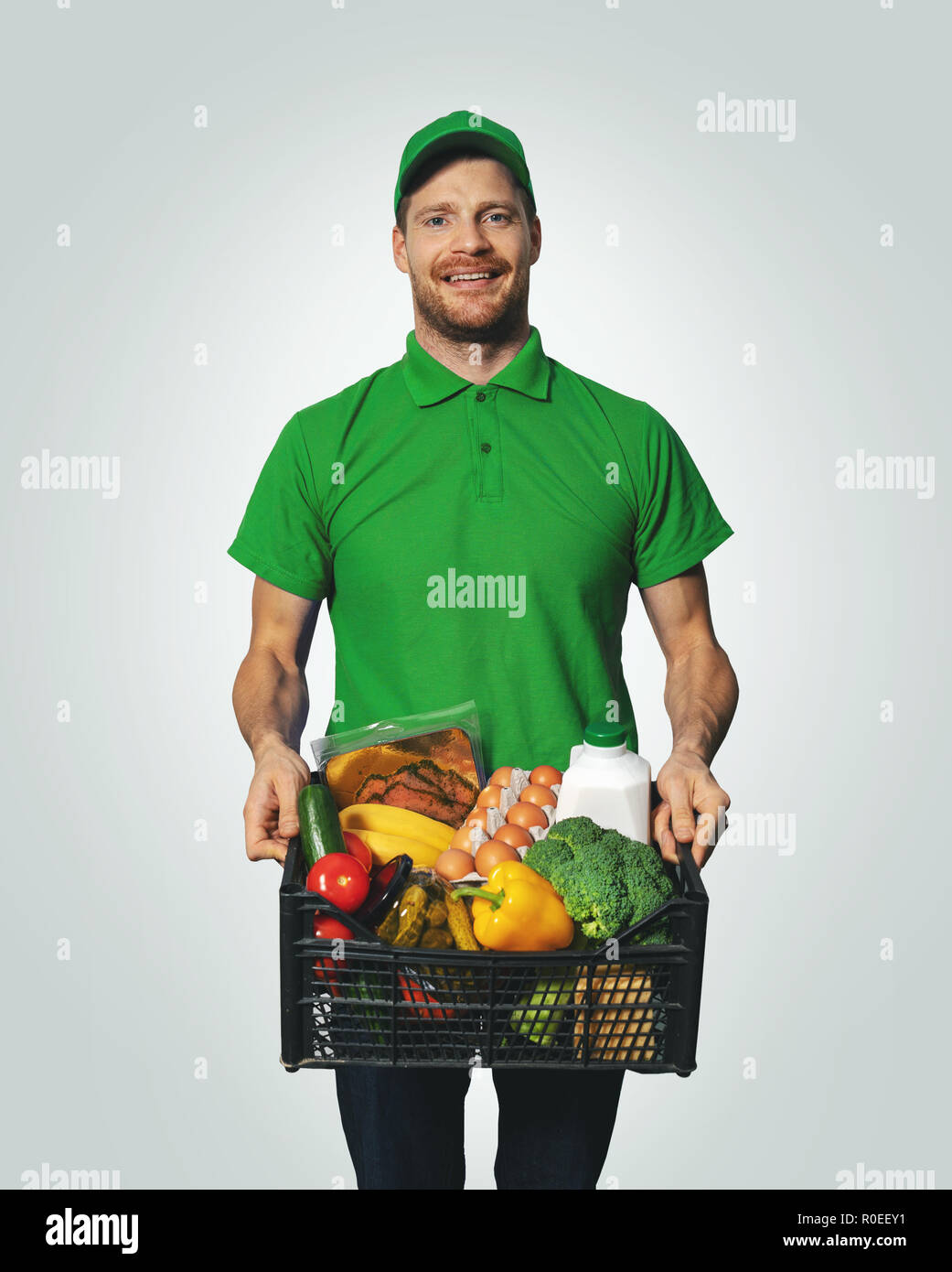 Lebensmittel Lieferung - Mann in der grünen Uniform mit Food Box Stockfoto
