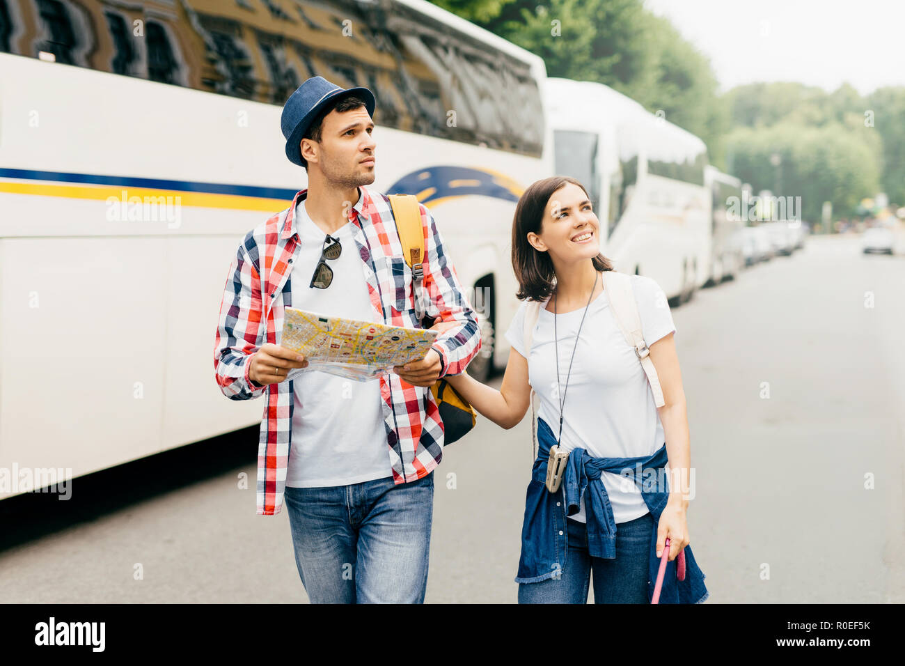 Die jungen wandern Paar durch Big City gehen, aufmerksam zur Seite suchen, mit City Guide für die Exploration neuer Orte auf der Karte. Familie Paar journe Stockfoto