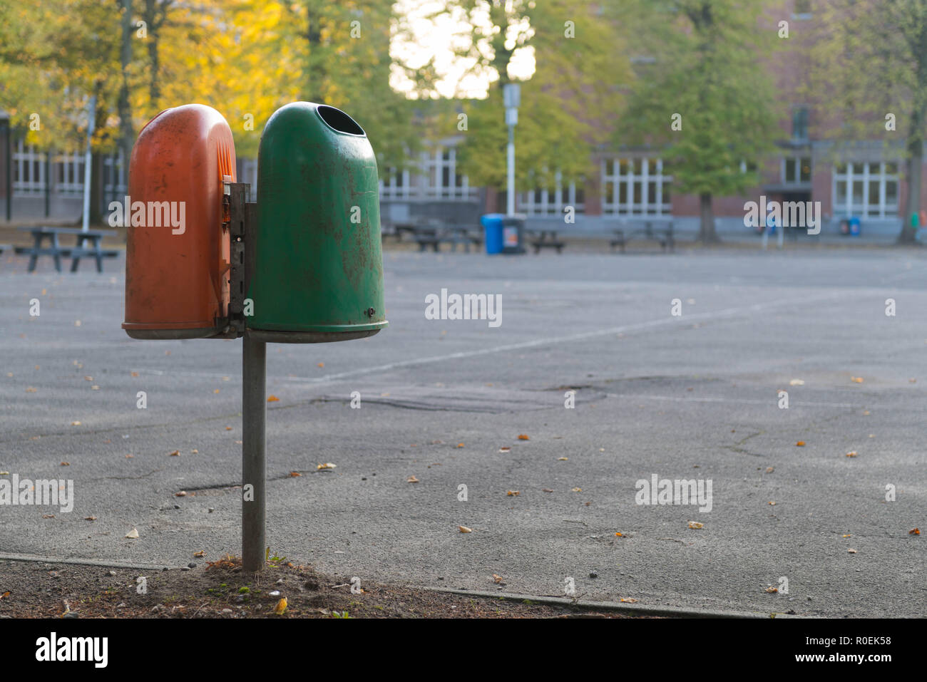 Orange und grüne Mülltonne auf Schulhof Stockfotografie - Alamy