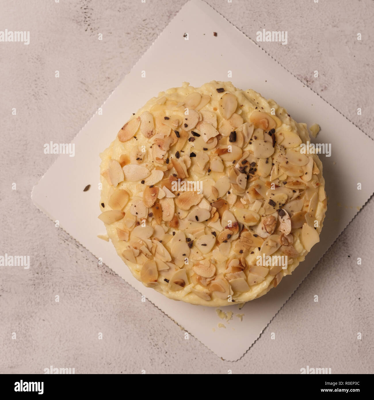 Gelbe Mandel Käse Kuchen auf einem weißen Teller platziert Stockfoto