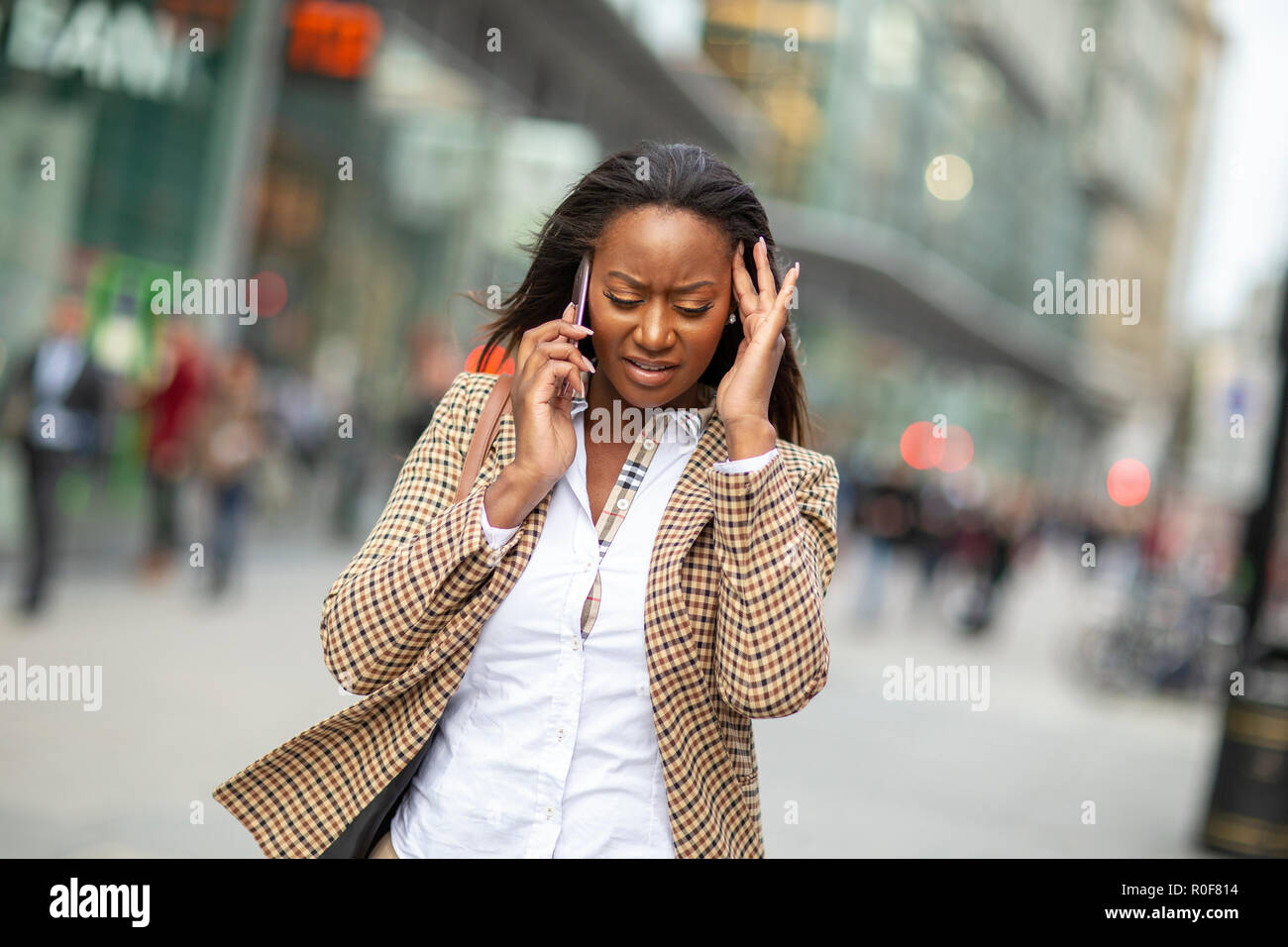 Junge Geschäftsfrau, die sich mit einem stressigen Anruf Stockfoto