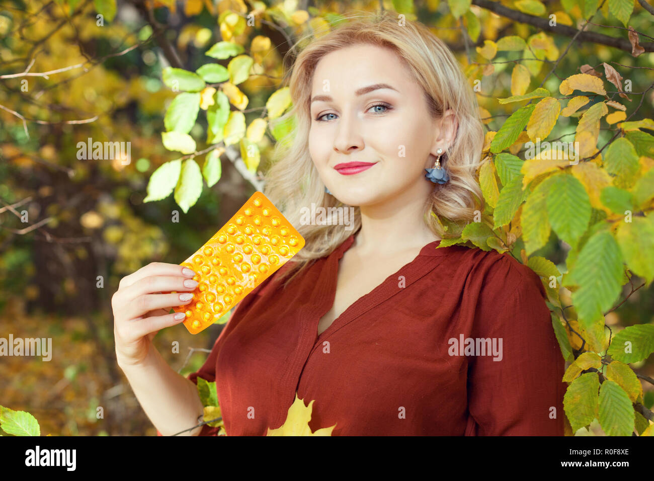 Junge Frau im Herbst Park. In die Hände ihrer Pillen. Stockfoto