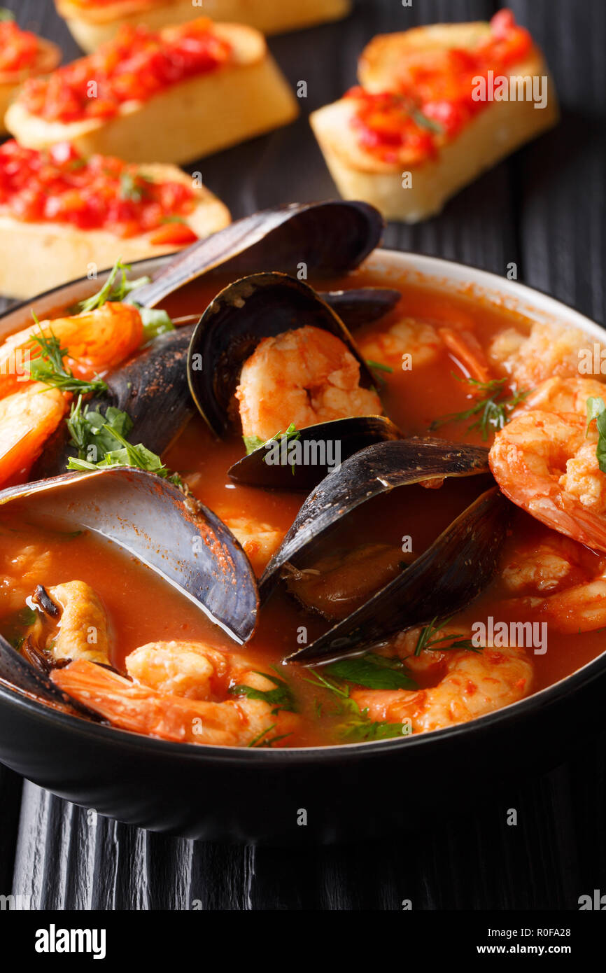 Traditionelle Marseille Fischsuppe bouillabaisse mit Garnelen, Fisch Filet und Muscheln closeup in einer Schüssel auf dem Tisch. Vertikale Stockfoto