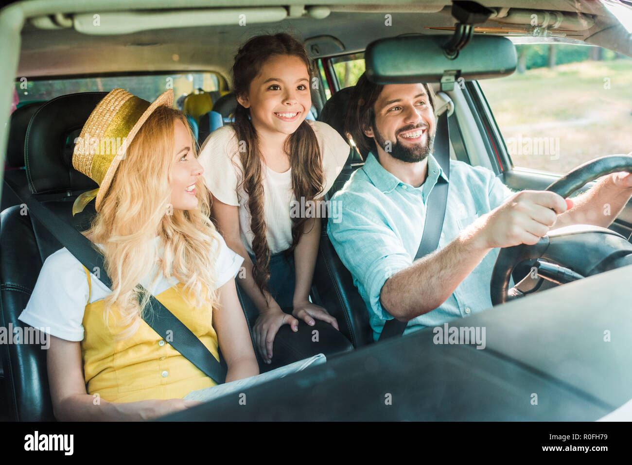 Glückliche Eltern und Tochter, die mit dem Auto anreisen Stockfoto