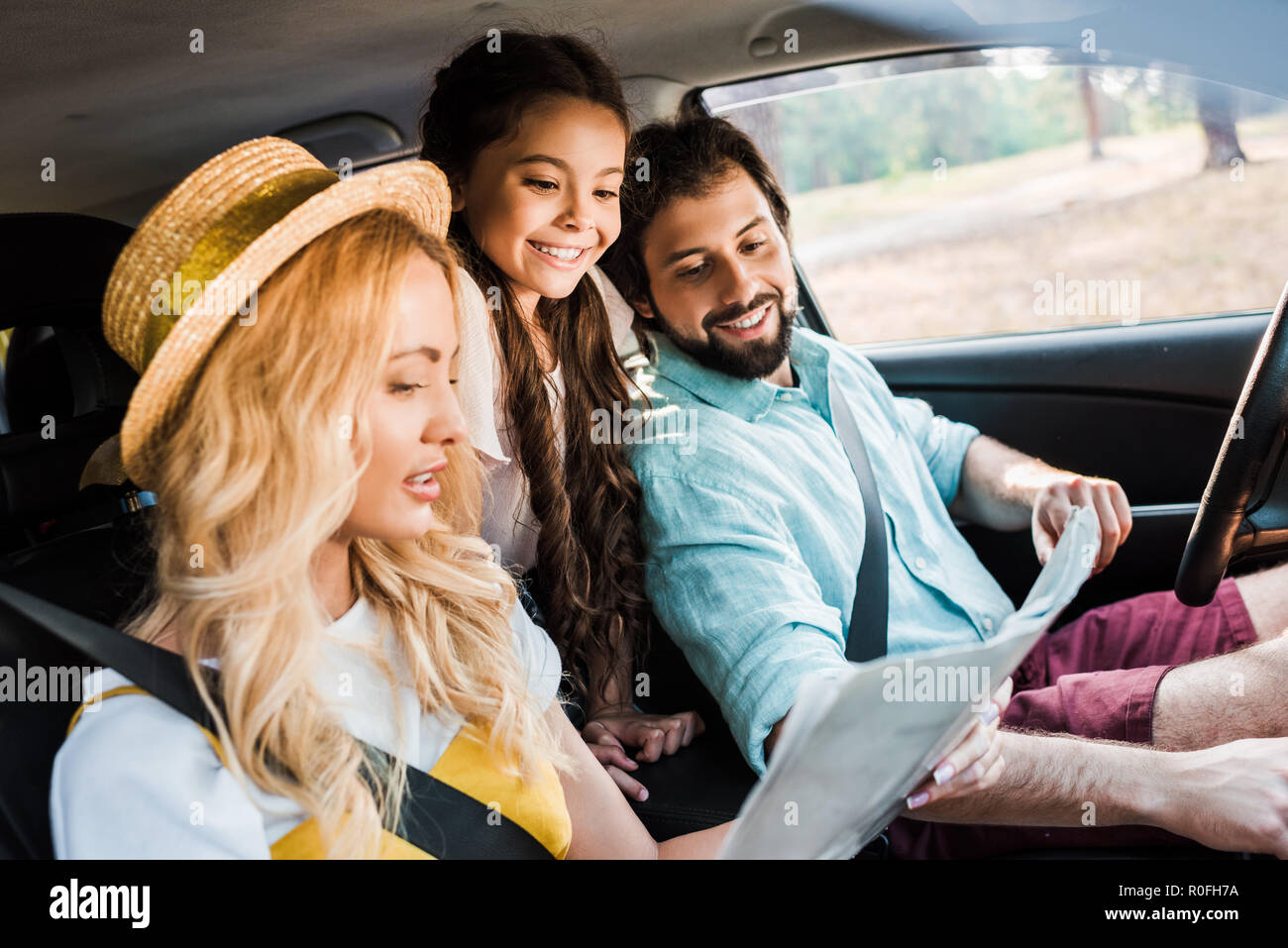 Eltern und Tochter suchen an der Karte während der Reisen mit dem Auto Stockfoto