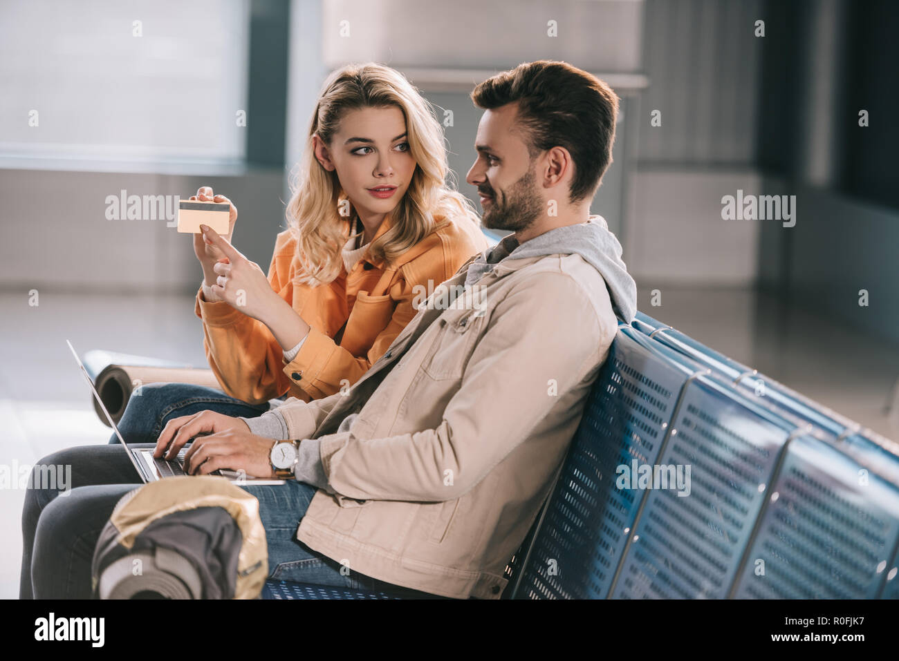 Mädchen mit Kreditkarte lächelnden Mann mit Laptop im Flughafen Stockfoto
