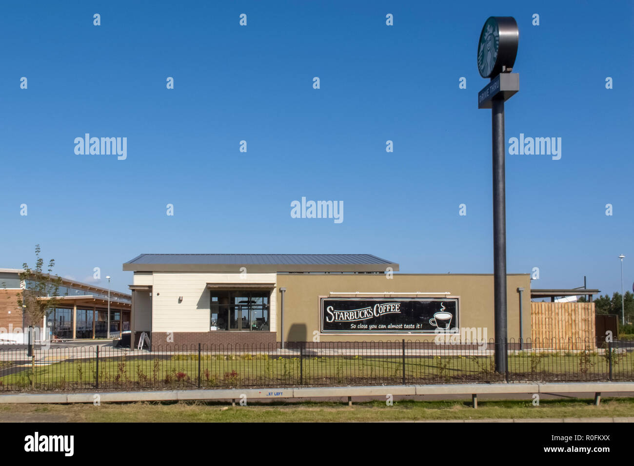 Ein Starbucks Coffee Shop und Drive Thru neben einem großen Supermarkt in Consett, County Durham, UK Stockfoto