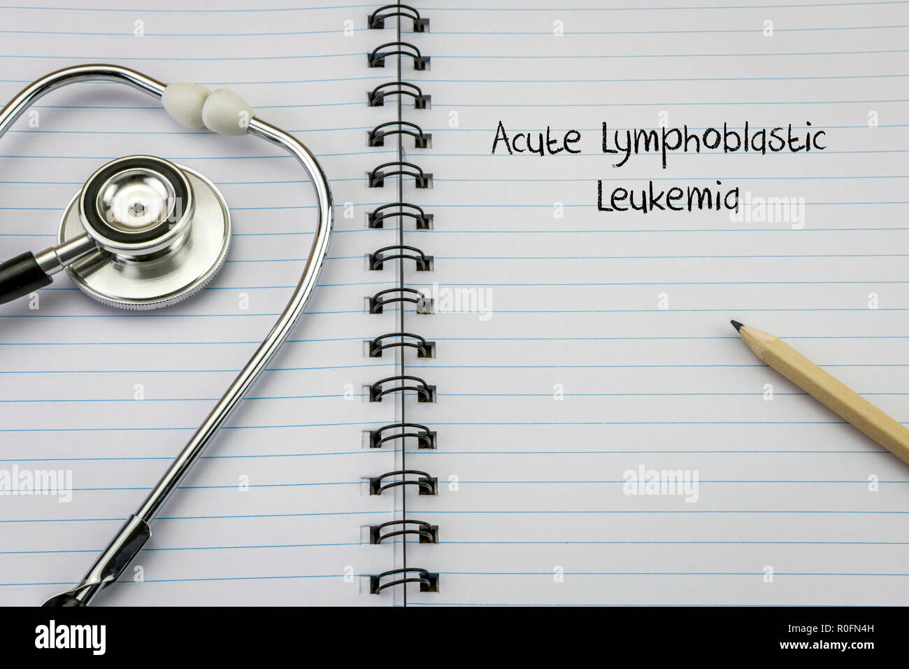 Stethoskop auf Notizbuch und Bleistift mit akuter lymphoblastischer Leukämie Worte als Stockfoto