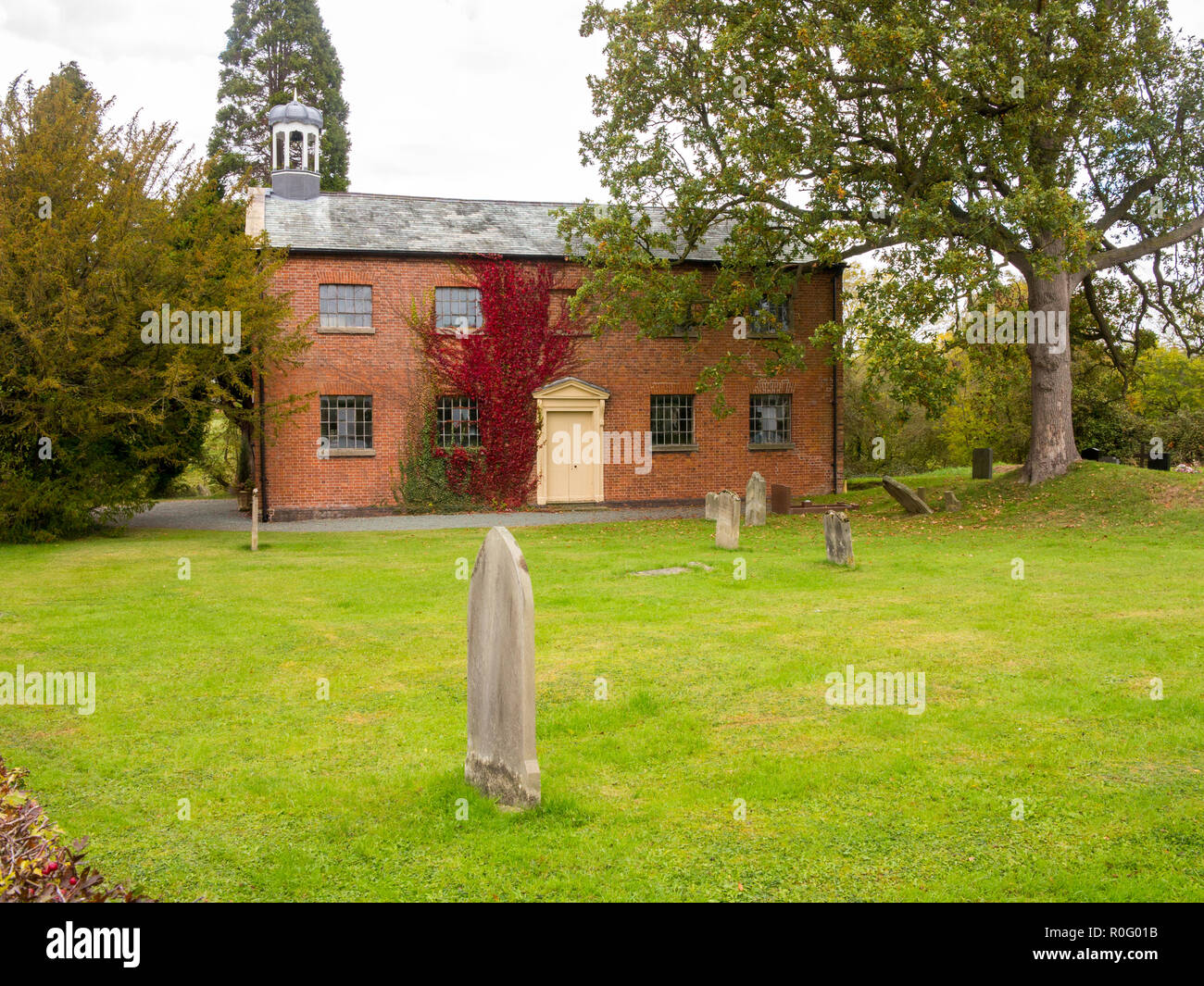 St John's Kirche und Friedhof mit Grabsteinen im Dorf Threapwood, Malpas Cheshire, England. Es ist ein aktiver Anglikanische Pfarrkirche Stockfoto