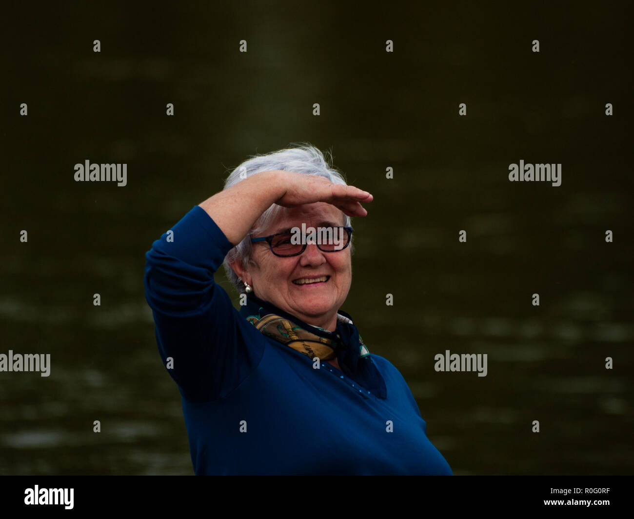 Una Mujer Bürgermeister gesticulando y sonriendo a la orilla del Río Stockfoto