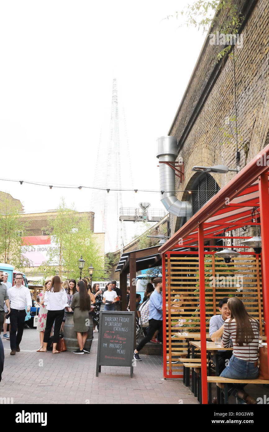 Bügeleisen Square, ein Knotenpunkt für Essen, Trinken und Tanzen im Schatten der Shard, in Southwark, SE London, Großbritannien Stockfoto