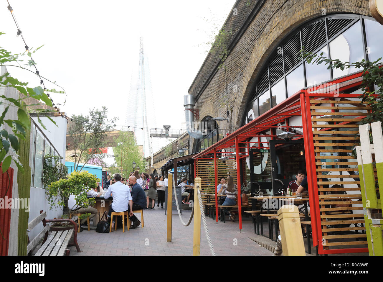 Bügeleisen Square, ein Knotenpunkt für Essen, Trinken und Tanzen im Schatten der Shard, in Southwark, SE London, Großbritannien Stockfoto