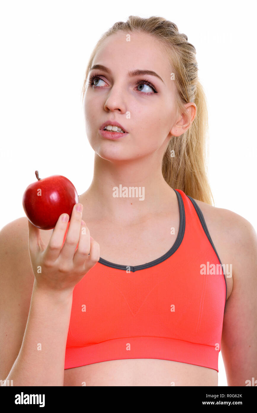 Gesicht der jungen schönen Mädchen im Teenageralter holding red apple während Thi Stockfoto