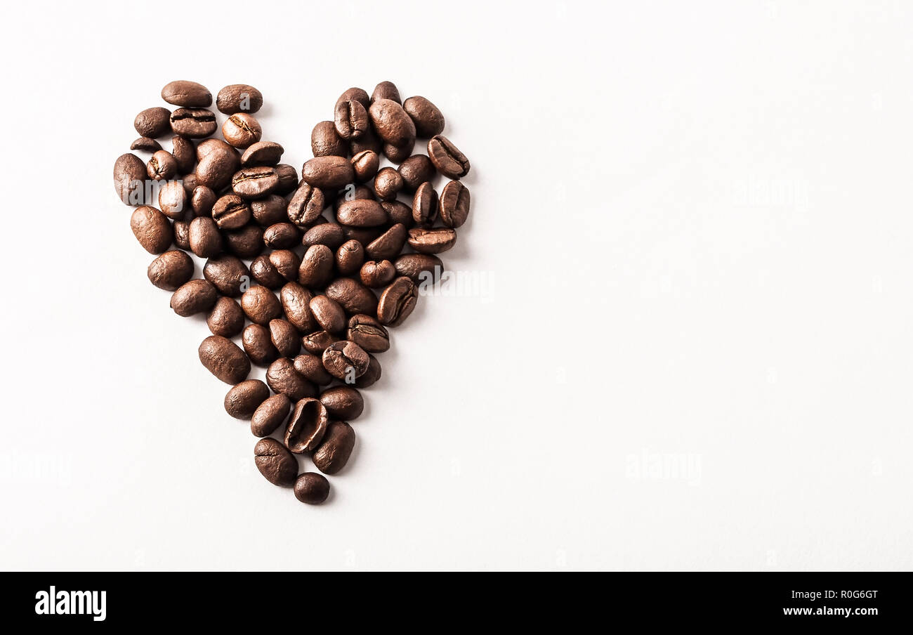 Fair trade Bio Kaffeebohnen geröstet als Herz auf weißem Hintergrund - Konzept des Koffeins Liebe, Frühstück, decaf oder morgen Zufriedenheit geprägt Stockfoto