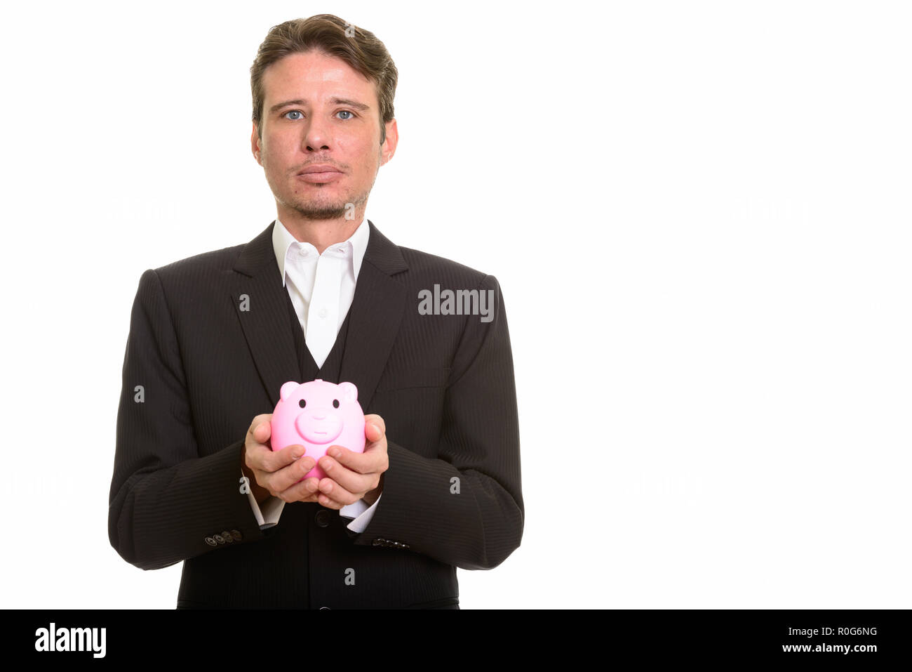 Kaukasische Geschäftsmann holding Sparschwein und Kamera Stockfoto