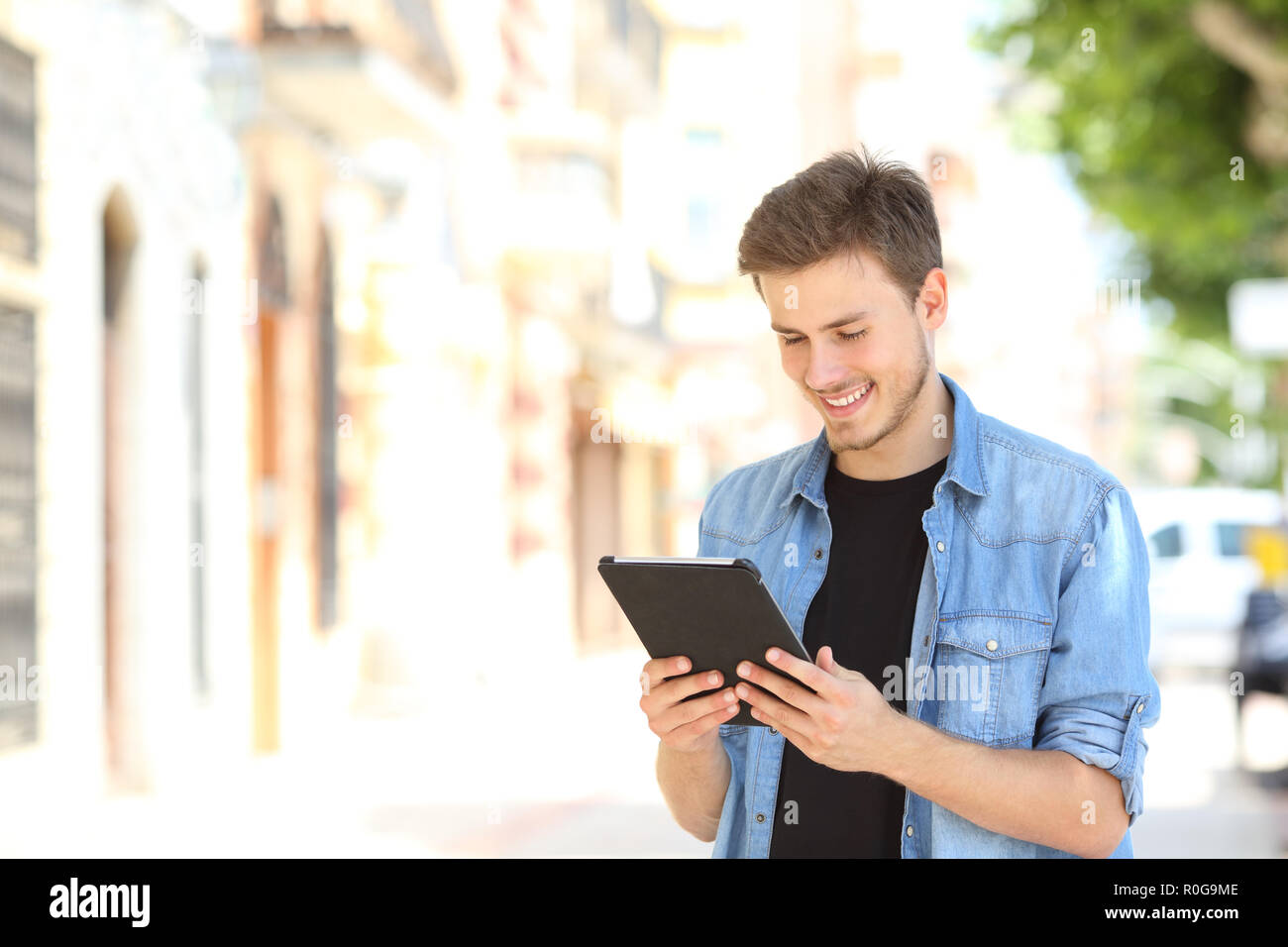 Glückliche Menschen mit einem Tablet online Content auf der Straße zu beobachten Stockfoto