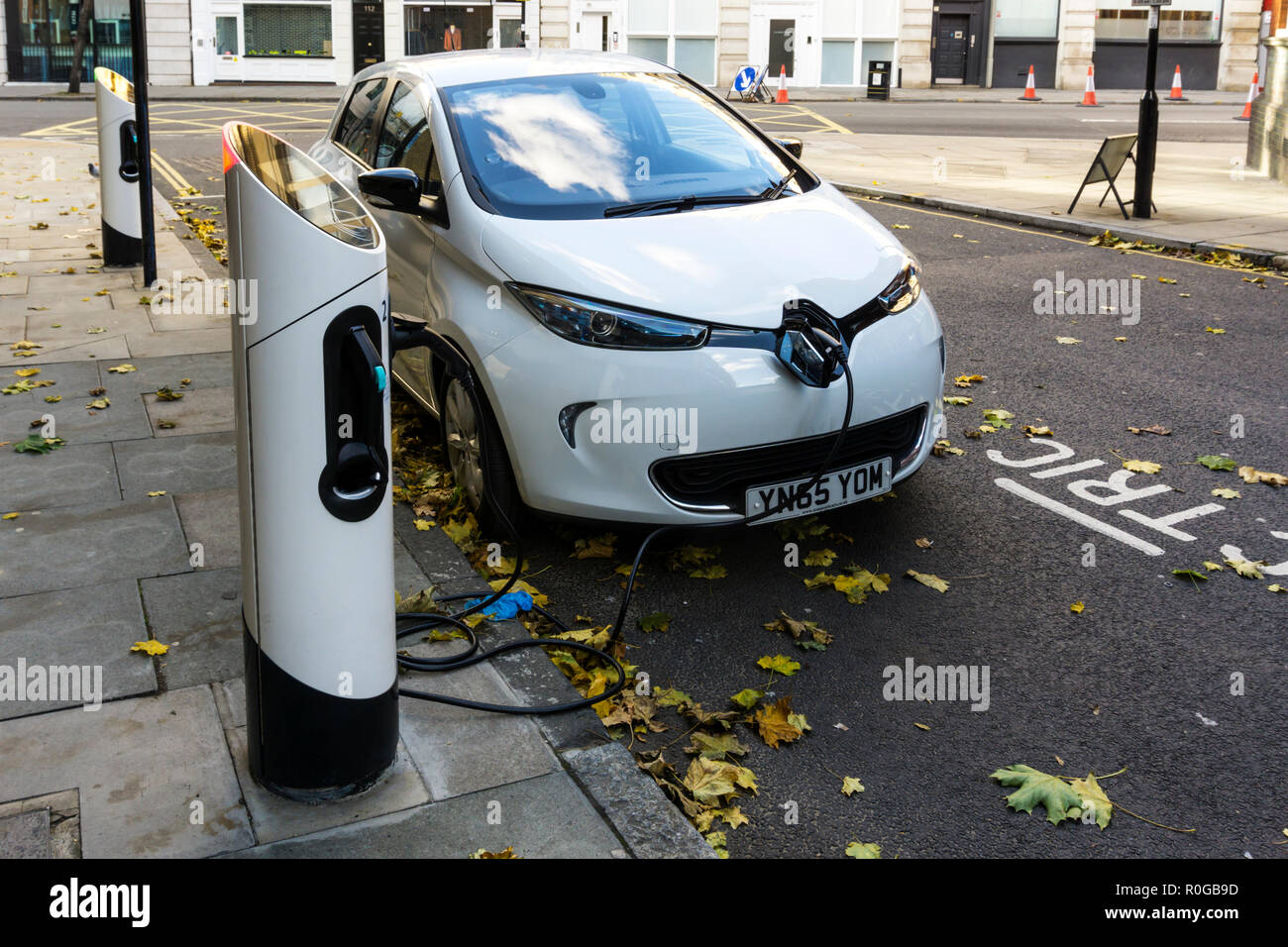 Weiß Renault Zoe Dynamique NAV Elektroauto aufladen an curbside Ladestationen. Stockfoto