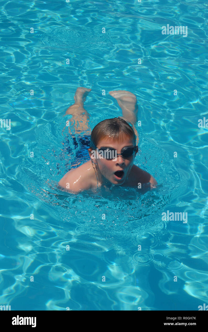 Zehn Jahre alten Jungen tragen Schutzbrille schwimmen im Pool. Stockfoto