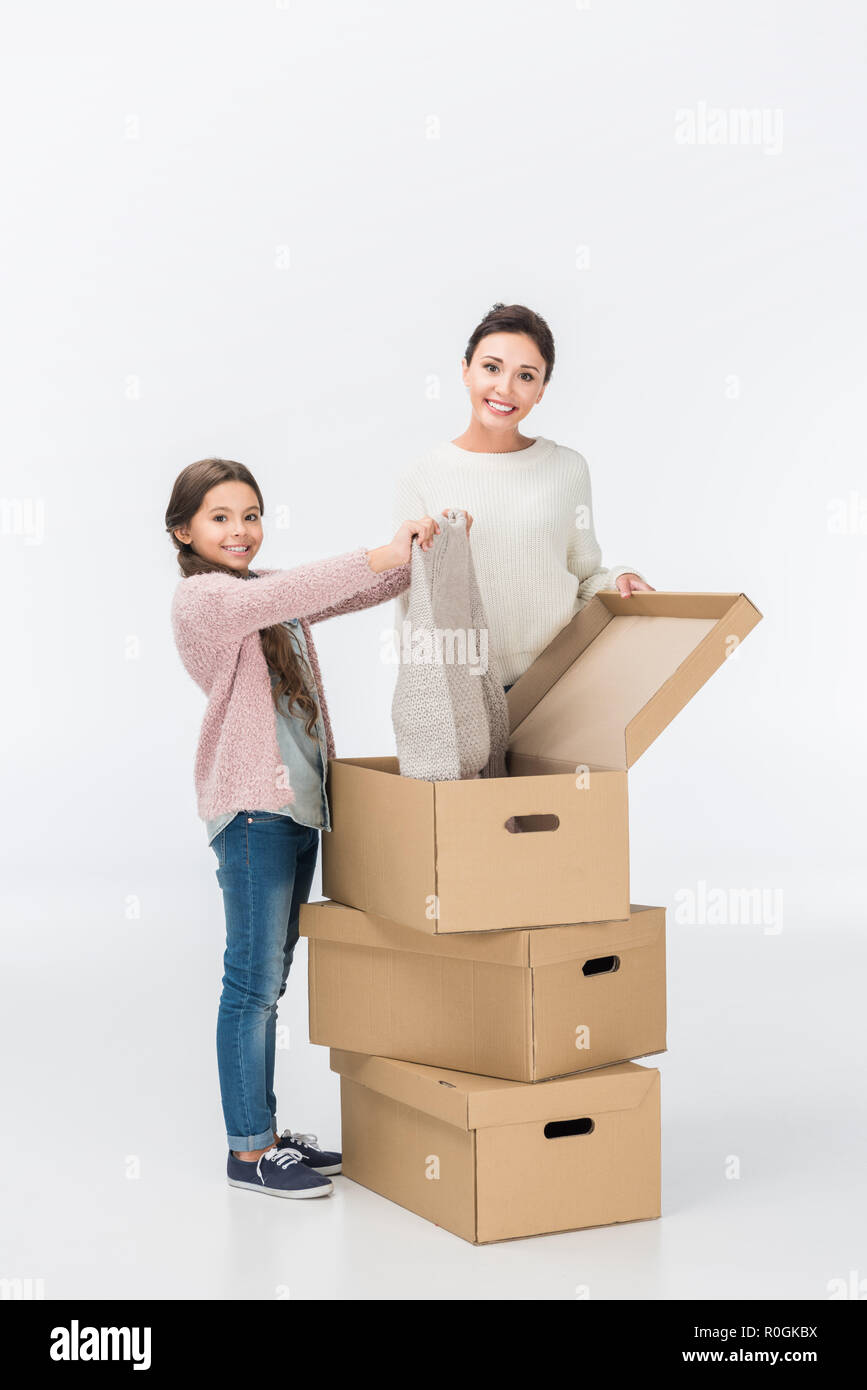 Glückliche Mutter und Tochter mit Kartons Umzug in neues Haus isoliert auf weißem Stockfoto