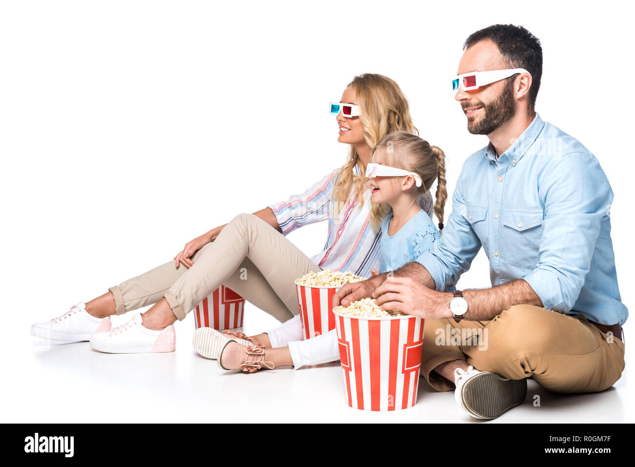 Familie mit Popcorn Film aufpassend isoliert auf weißem Stockfoto