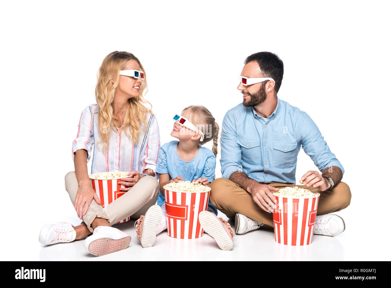 Familie mit Popcorn und 3D-Brille isoliert auf weißem Stockfoto