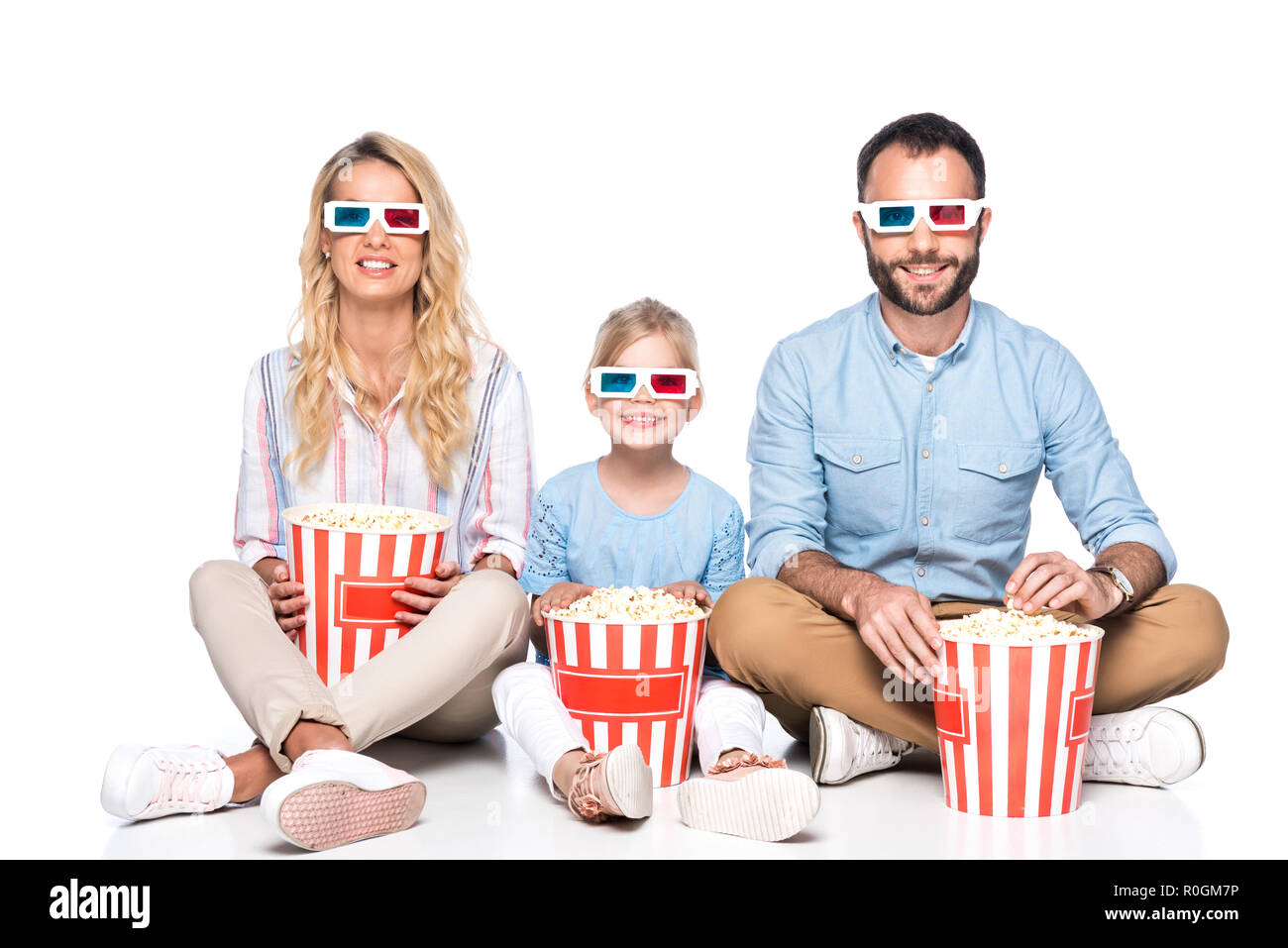 Glückliche Familie mit Popcorn isoliert auf weißem Stockfoto
