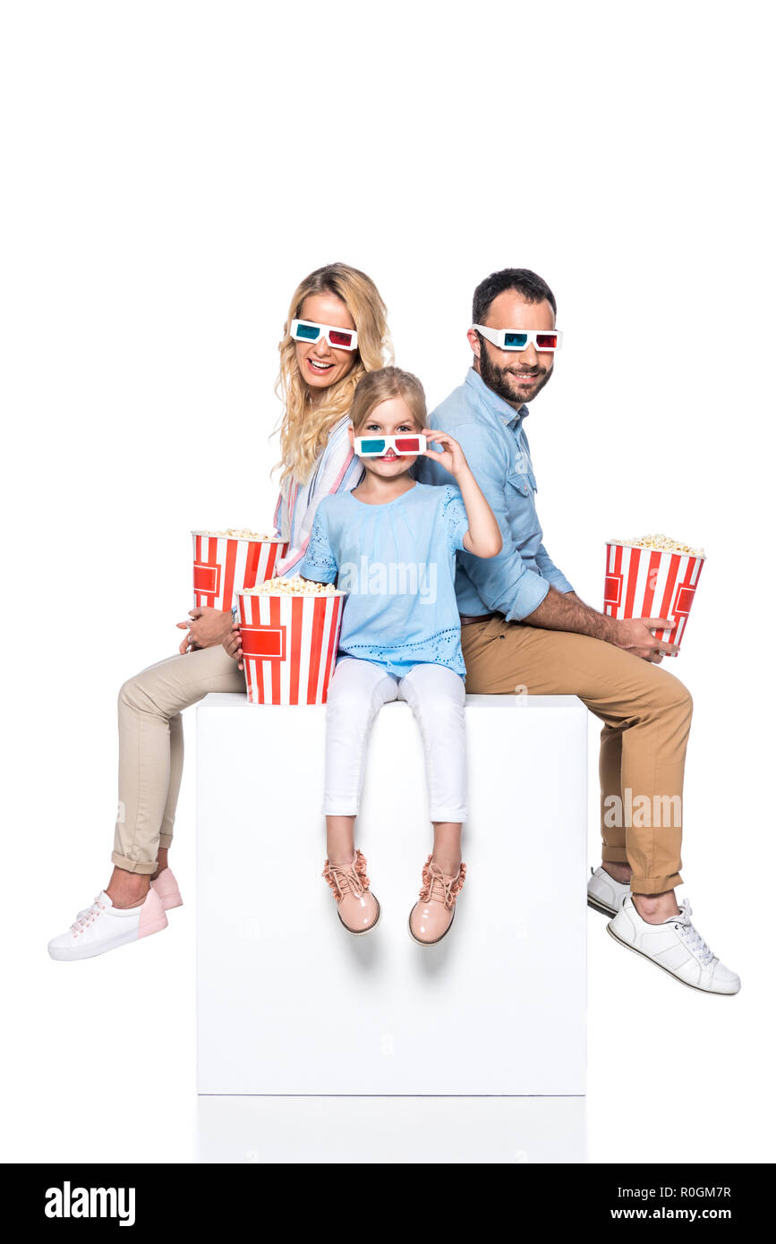 Familie mit Popcorn sitzen auf White Cube isoliert auf weißem Stockfoto