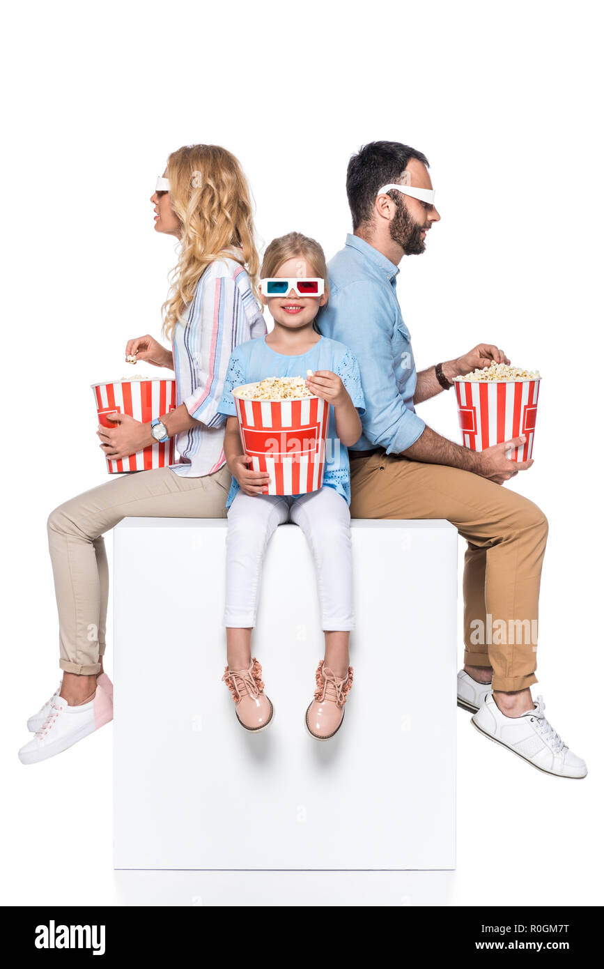 Familie essen Popcorn sitzen auf White Cube isoliert auf weißem Stockfoto