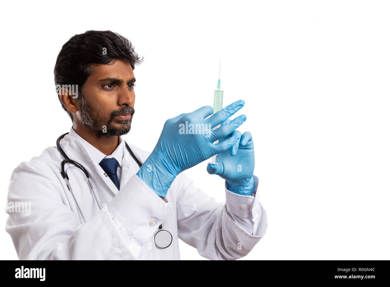 Indische Arzt männlichen Spritze mit Medizin auf weißem studio Hintergrund konzentriert Stockfoto