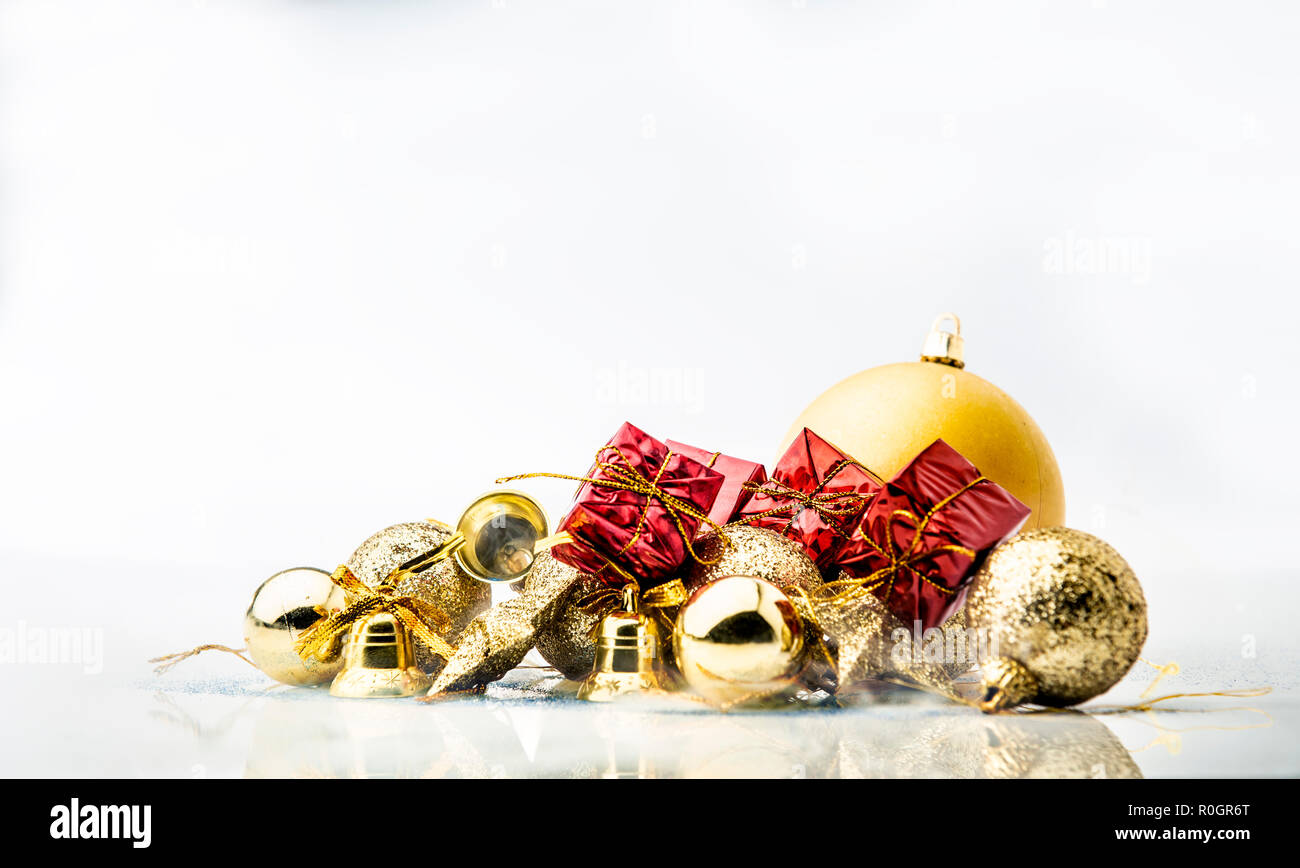 Red Geschenkboxen und goldene Weihnachtskugeln auf weißem Hintergrund Stockfoto