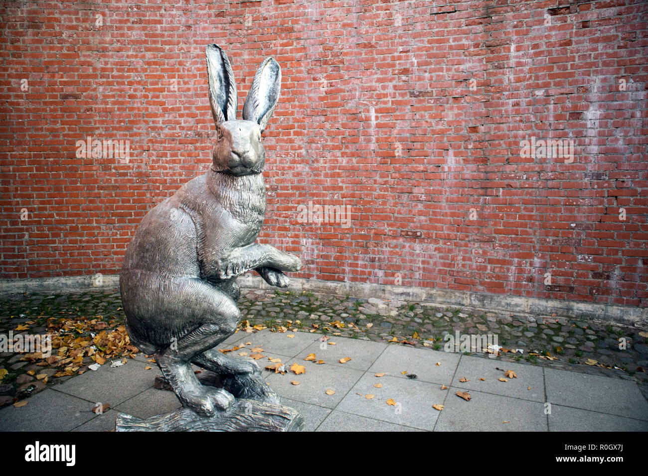 Grauer Kunststoff menschlichen Höhe Statue von Hase gegen die Mauer in der Peter und Paul Festung Stockfoto