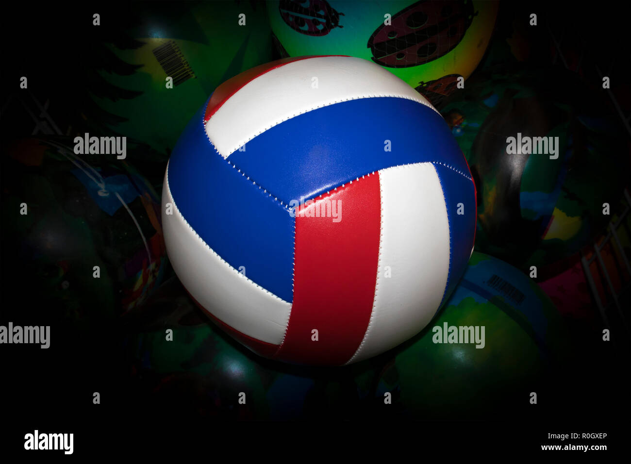Gestreift volleyball Ball gegen grün lackiert Kugeln mit dunklen Vignette Stockfoto