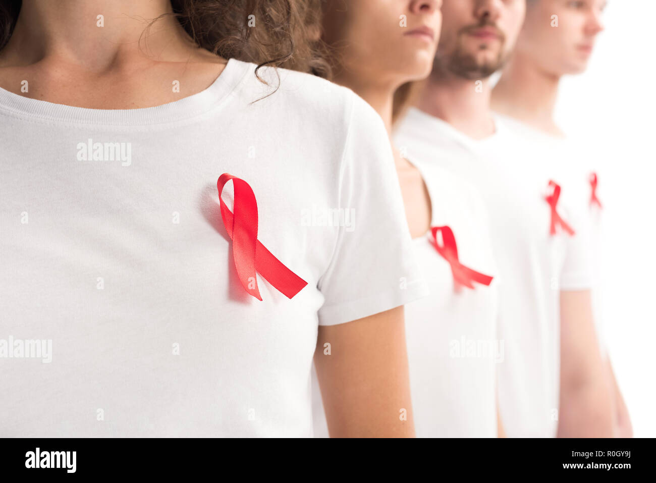 Zugeschnittenes Bild von Menschen mit roten Bändern auf weißen Shirts isoliert auf Weiss, welt-aids-tag Konzept Stockfoto