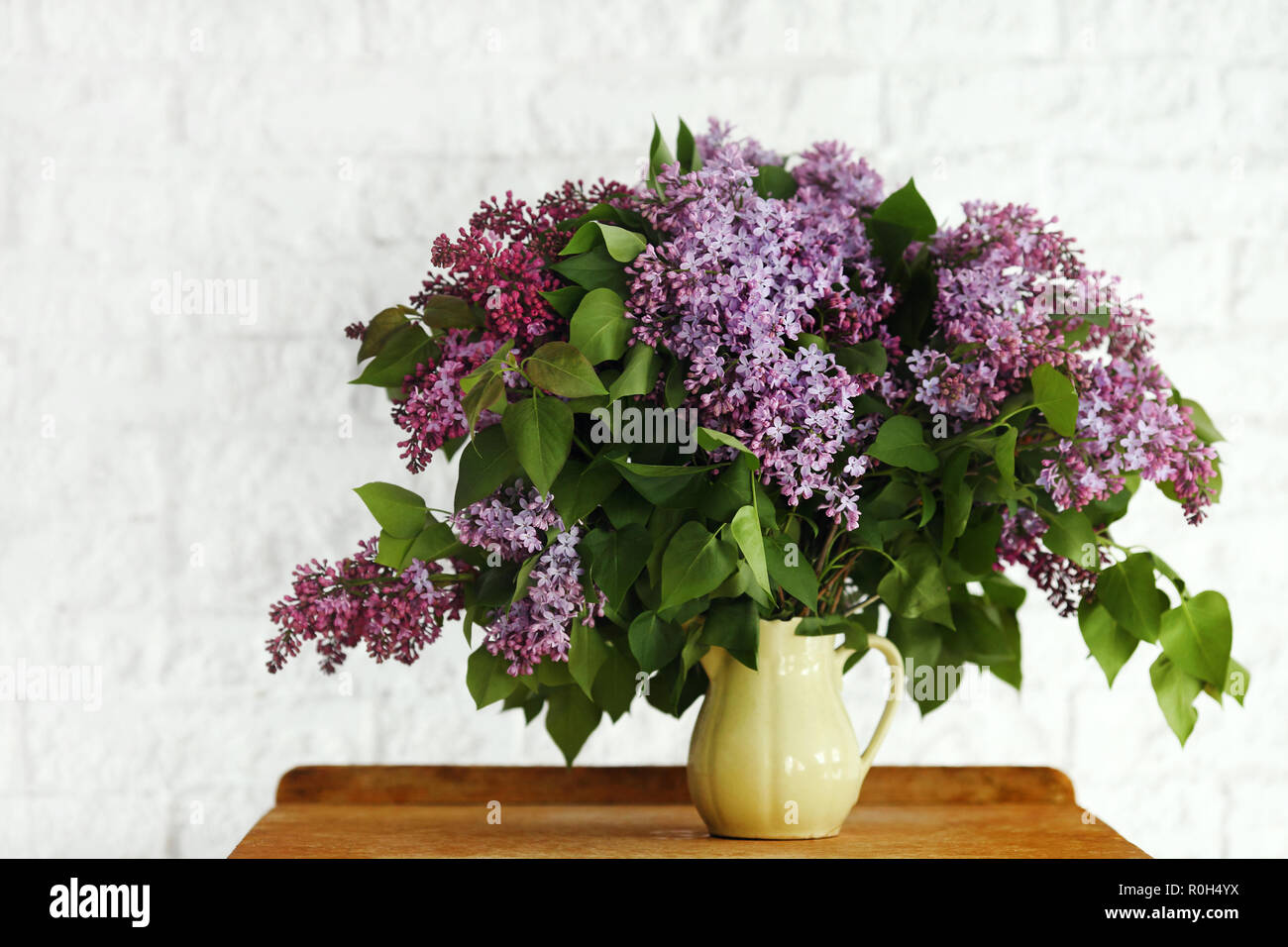 Lila Blume in einer Vase auf einem hölzernen Hintergrund Stockfoto