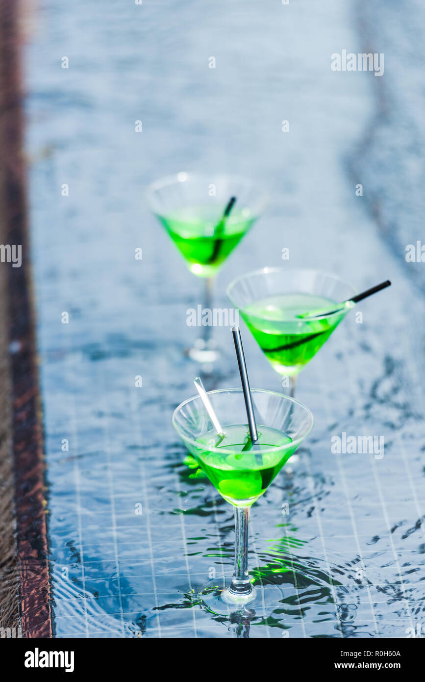 Nahaufnahme, Ansicht von Gläsern mit grünen Cocktails mit Strohhalm am Pool Stockfoto