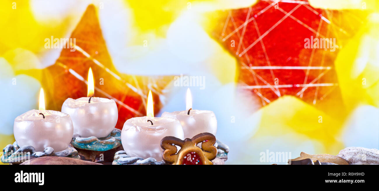 Adventskranz mit brennenden Kerzen auf dem roten Hintergrund Stockfoto