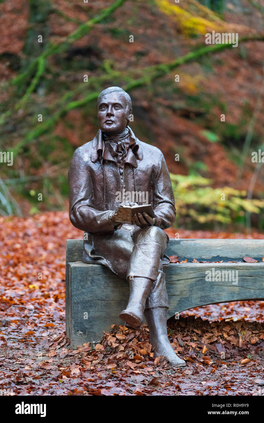 Statue des Dichters Robert Burns sitzt auf der Bank im Herbst am Birks O'Aberfeldy Scenic Area in Aberfeldy, Perthshire, Schottland, Großbritannien Stockfoto