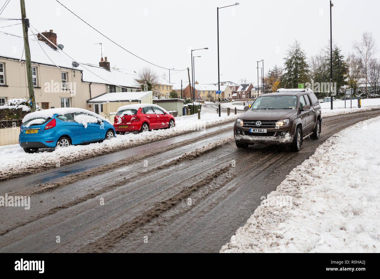 Autos fahren durch Schneematsch in Street, Abergavenny, Wales, Großbritannien Stockfoto