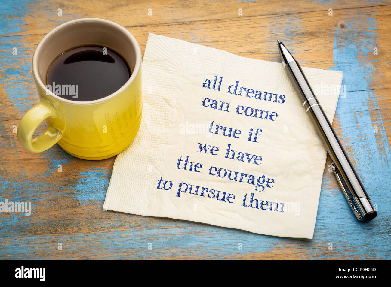 Alle Träume können wahr werden, wenn Sie den Mut haben, sie auszuüben - Handschrift auf eine Serviette mit einer Tasse Espresso Stockfoto