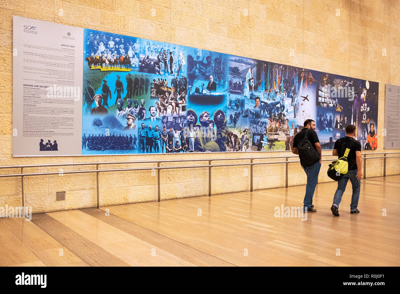 Zwei Reisende übergeben eine der "120 Jahre Wandmalereien Zionismus' am Flughafen Ben Gurion in Tel Aviv, Israel. Stockfoto
