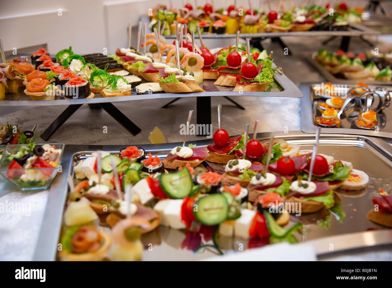 Catering Service am Tisch verschiedene Snacks auf einen Tisch am Bankett gesetzt. Der kalte Snacks, canape, Getränke, Nahaufnahme. Von der Seite. Bankett Tisch Stockfoto