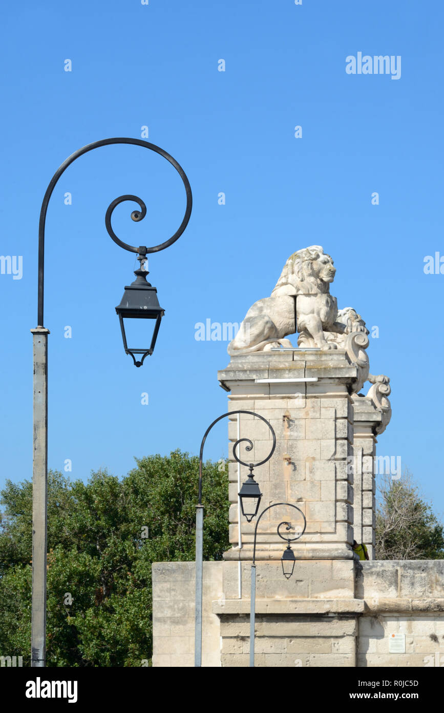 Moderne Straßenbeleuchtung oder Lampen und geschnitzten steinernen Löwen auf Spalten oder ehemaligen Hängebrücke über den Fluss Rhône Arles Provence Frankreich Stockfoto